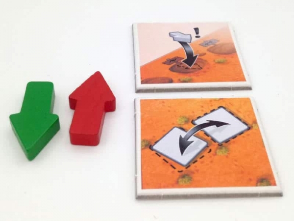Two of the arrow tokens and two action tiles from Outback Crossings (photo courtesy of Mücke Spiele)