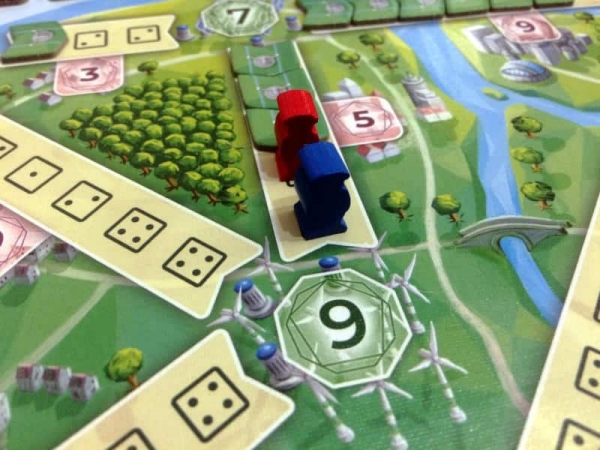 A close-up of the player boards with the powerlines and their pip values, as well as the differently coloured workers that represent the dice