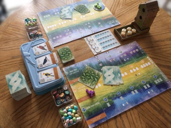 A game of Wingspan set up on the table, with the cardboard dice tower, plastic card draw, etc.